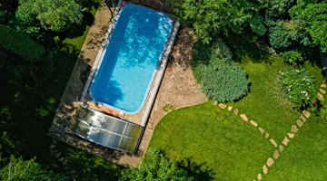 Swimming pool in beautiful garden aerial top view from above