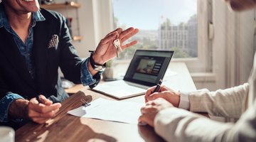 Client signing contract while real estate agent holding keys