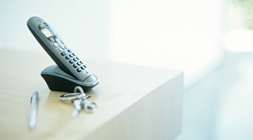 Cordless phone on table by keys and pen,differential focus