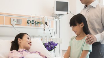 Family visiting the mother in the hospital, holding hands