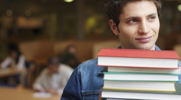 Student holding books in library