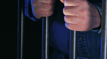 Hands holding jail cell bars